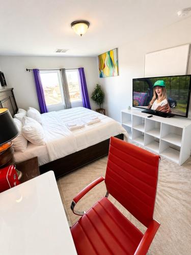 a bedroom with a bed and a red chair at Penn Signature Airport Short Term Rental PHX in Phoenix