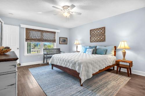 a bedroom with a bed and a ceiling fan at Clear For Take Off by Oak Island Accommodations in Caswell Beach