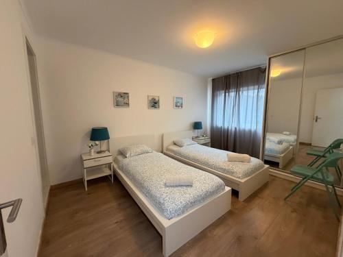 a bedroom with two beds and a mirror at Suites Setúbal - River View in Setúbal