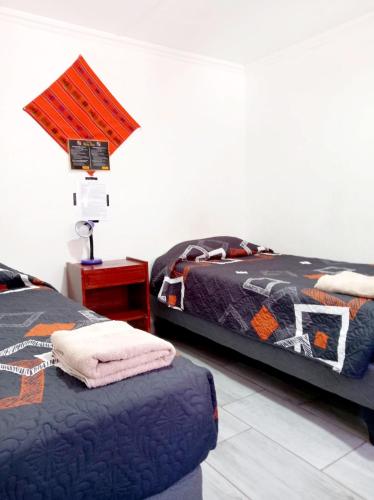 a bedroom with two beds and a table with a lamp at Misky Wasi in San Pedro de Atacama