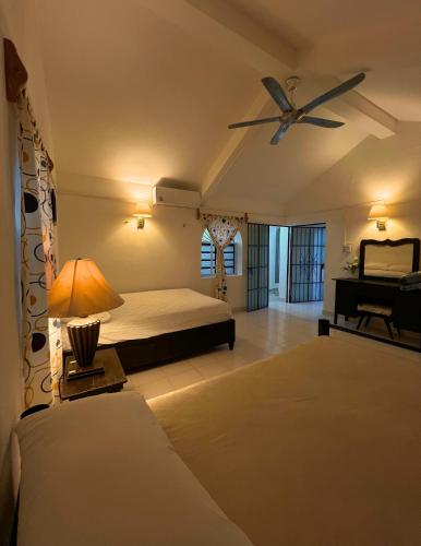 a bedroom with a bed and a ceiling fan at Villa X'Cocay in Valladolid
