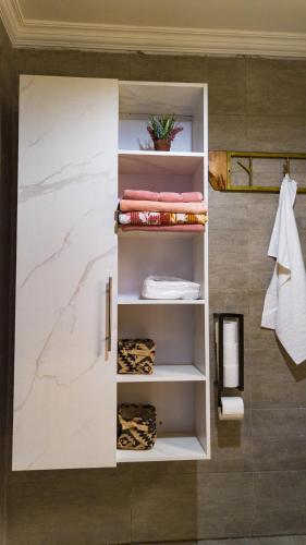 a bathroom with a white cabinet with towels at The apartment Bwebajja 3 in Namulanda