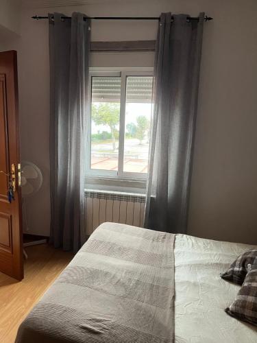 a bedroom with a bed and a window at Pensión Restaurante Verdemar in Vigo