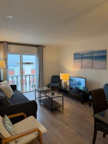 a living room with a couch and a tv at Suites Setúbal - River View in Setúbal