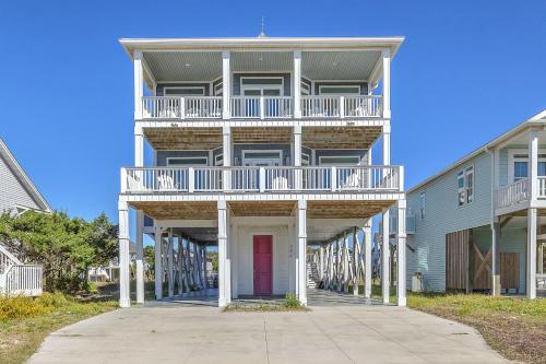 a large apartment building with a red door at Conch Out by Oak Island Accommodations in Oak Island