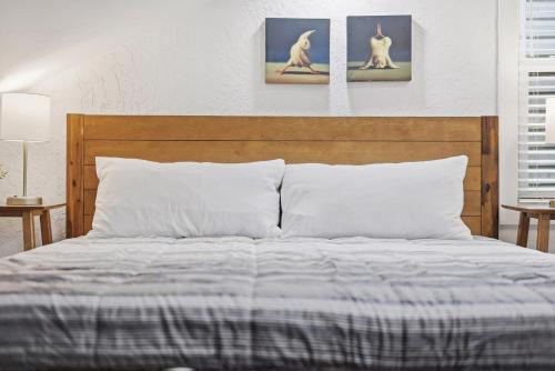 a bed with a wooden headboard and two pictures of dogs at Pittsburgh Millvale E Modern and Quiet Private Bedroom with Shared Bathroom in Pittsburgh