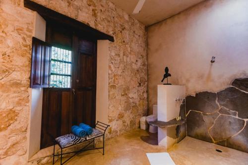 a room with a stone wall and a door at Hacienda Sacnicte in Izamal