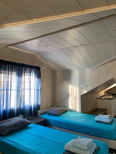 a room with two blue beds in it at Nadia's Beach House in Pefkari