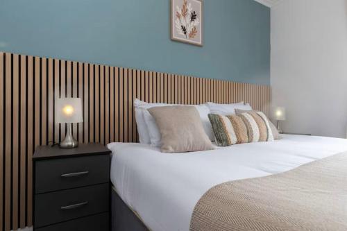 a bedroom with a large bed with a wooden headboard at 4BR Home with Parking Ideal for Contractors in Durham