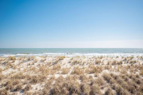 an empty beach with the ocean in the background at Dip Inn by Oak Island Accommodations in Oak Island