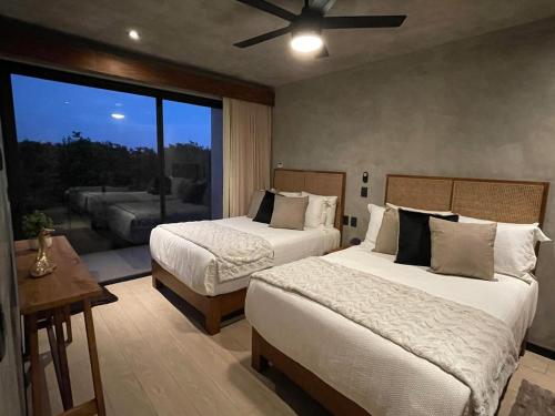a bedroom with two beds and a large window at PH 3-Bedroom Private Pool in TUK in Tulum