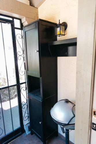 a black cabinet with a stool in front of a window at Calle Condo in Green Valley