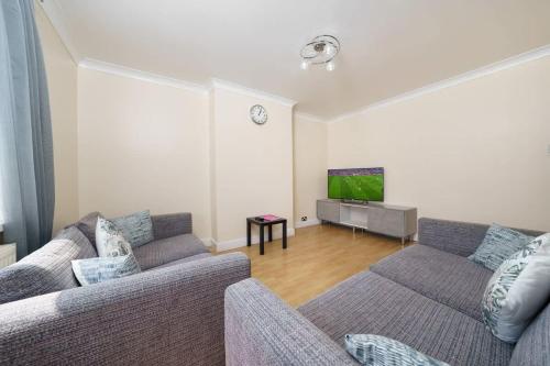a living room with two couches and a tv at 2BR Apartment near Heathrow Airport in Wallington