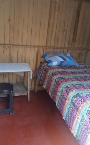 a bedroom with a bed and a table in a room at Fure Wassi Hostel in Cabanaconde