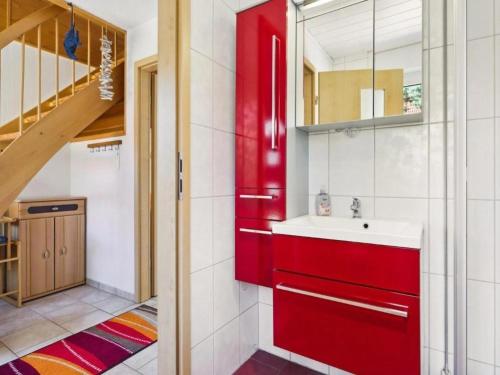 a bathroom with a red cabinet and a sink at Delphin in Pruchten
