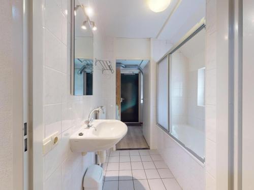 ein weißes Badezimmer mit Waschbecken und Badewanne in der Unterkunft Borre Bos in Diever