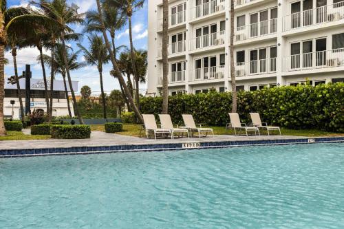 a swimming pool in front of a large building at Club Wyndham Sea Gardens in Pompano Beach