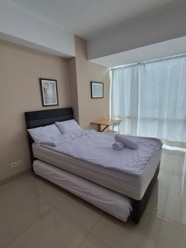 a bedroom with a bed and a window at Cozy 1BR UResidence 2 by REJA Essentials in Klapadua