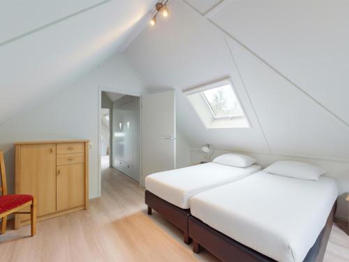 ein Dachgeschosszimmer mit zwei Betten und einem Fenster in der Unterkunft Borre Bos in Diever