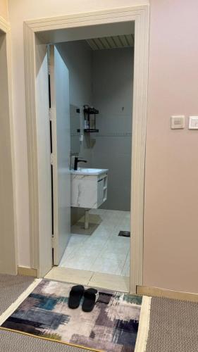 a doorway to a bathroom with a sink and shoes at شقق مرفا in Hail