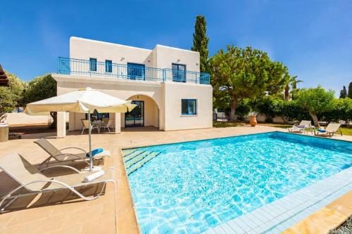 a villa with a swimming pool and a house at Villa Ermis in Peyia