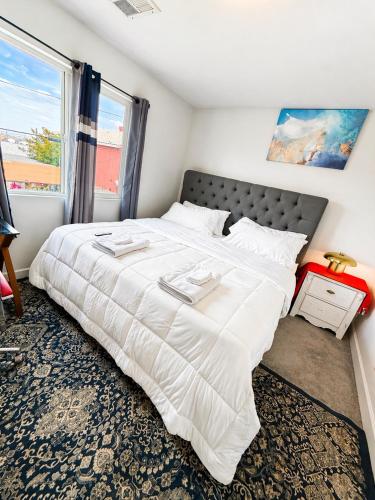 a large white bed in a room with a window at Penn Signature Airport Short Term Rental PHX in Phoenix