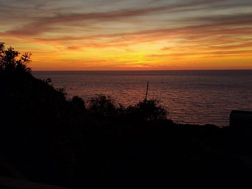 a sunset over a body of water with the ocean at MAREVIGLIOSO Fronte Mare Sea Front in Magomadas