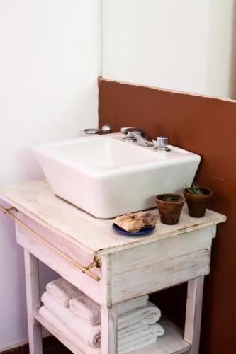 a white sink on a wooden table with towels at Quita penas in Los Reartes