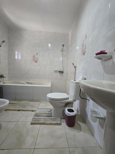 a bathroom with a toilet and a sink and a tub at Providence Guesthouse and Catering Services in Abidjan