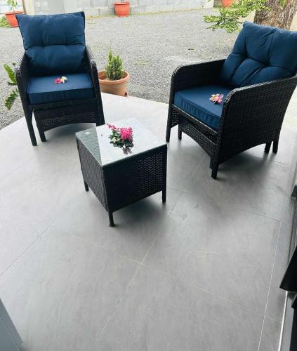 three chairs and a table with flowers on a patio at Matirina Ura lodge in Arue