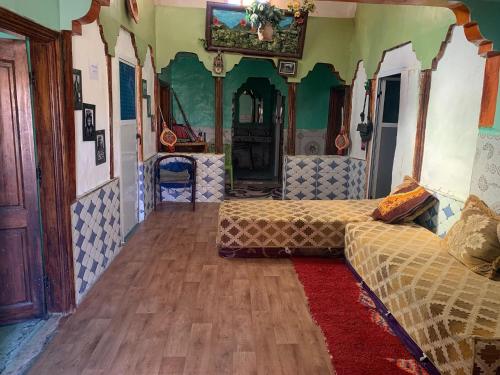 a room with two beds and a red rug at Auberge High Atlas B&B in Alemrhou