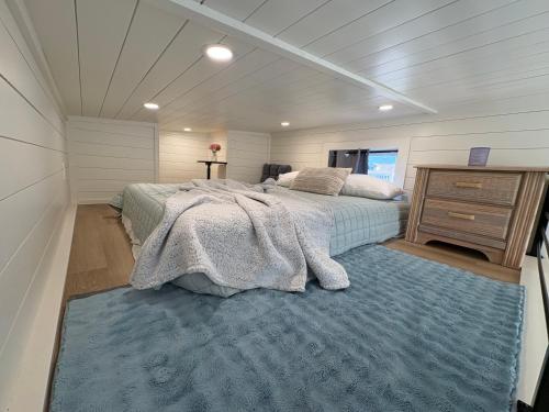 a bedroom with a large bed and a blue rug at Oceanfront Tiny Retreat in Holden Beach
