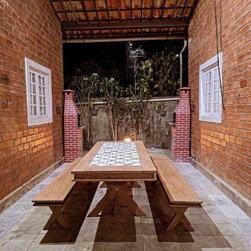 a wooden picnic table in a brick wall at Chalés serra negra in Bezerros