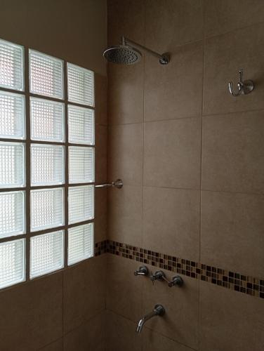 a bathroom with a shower with two sinks and a window at El DESCANSO HOSPEDAJE in Resistencia