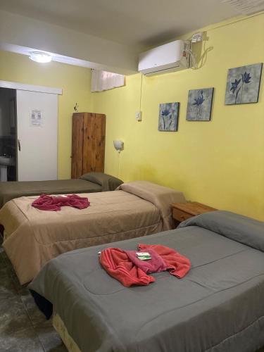 two beds in a room with red shirts on them at Hotel Norte in Río Tercero