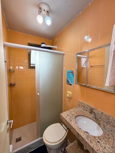 a bathroom with a toilet and a sink and a mirror at Refugio do Forte Cabo Frio in Cabo Frio