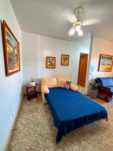 a bedroom with a bed with a blue blanket at Refugio do Forte Cabo Frio in Cabo Frio