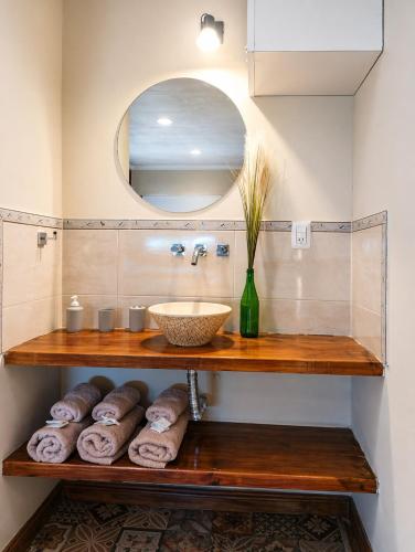 a bathroom with a sink and a shelf with towels at Duplex Mi Lar in Termas de Río Hondo