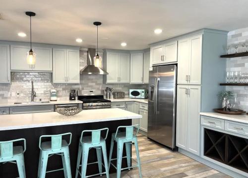 a kitchen with white cabinets and a island with bar stools at 508 Clubhouse in Newport Beach