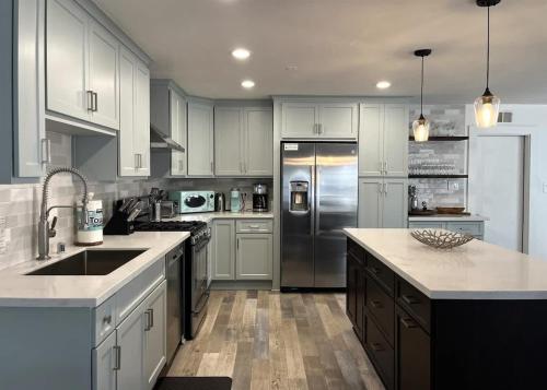 a kitchen with white cabinets and a stainless steel refrigerator at 508 Clubhouse in Newport Beach
