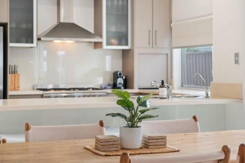 a kitchen with a wooden table with a plant on it at Pet Friendly Modern Oasis with Private Pool in Noosaville