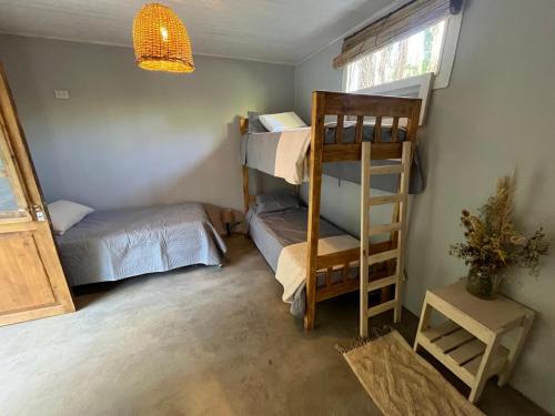 a room with a bunk bed and a ladder at Dormis El Alba in Barreal