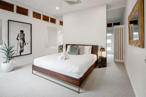 a bedroom with a large bed in a room at Modern airy duplex steps to River heated pool in Noosaville