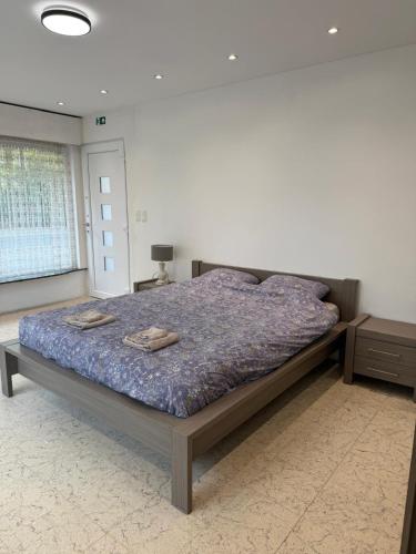 a bedroom with a bed with two towels on it at The Wandering House in Tremelo
