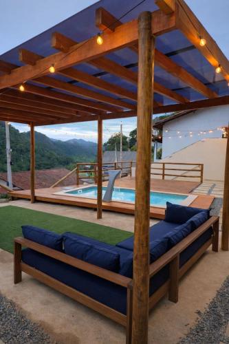 a patio with a couch and a swimming pool at Chalé loft reserva Refúgio nas Montanhas in Marechal Floriano
