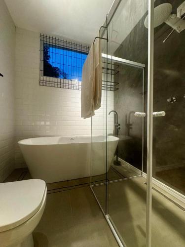a bathroom with a tub and a toilet and a shower at Chalé loft reserva Refúgio nas Montanhas in Marechal Floriano