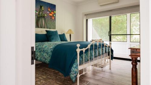 a bedroom with a bed with a blue comforter at Kingfisher Cottage in Broughton Vale
