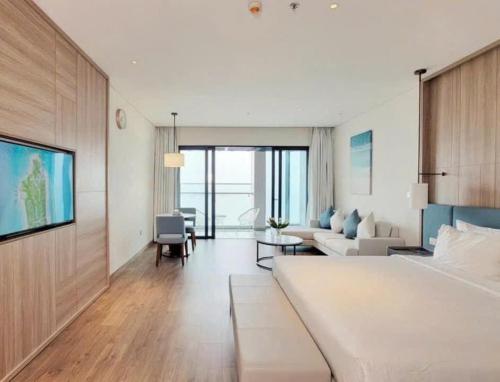 a bedroom with a large bed and a living room at À La Carte Hạ Long in Ha Long