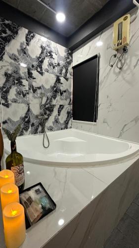 a bathroom with a tub and a tv on a wall at Villa Moon Terrace in Bang Khen