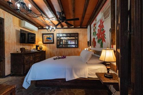 a bedroom with a bed and a table and a lamp at Posada de las Flores Loreto in Loreto